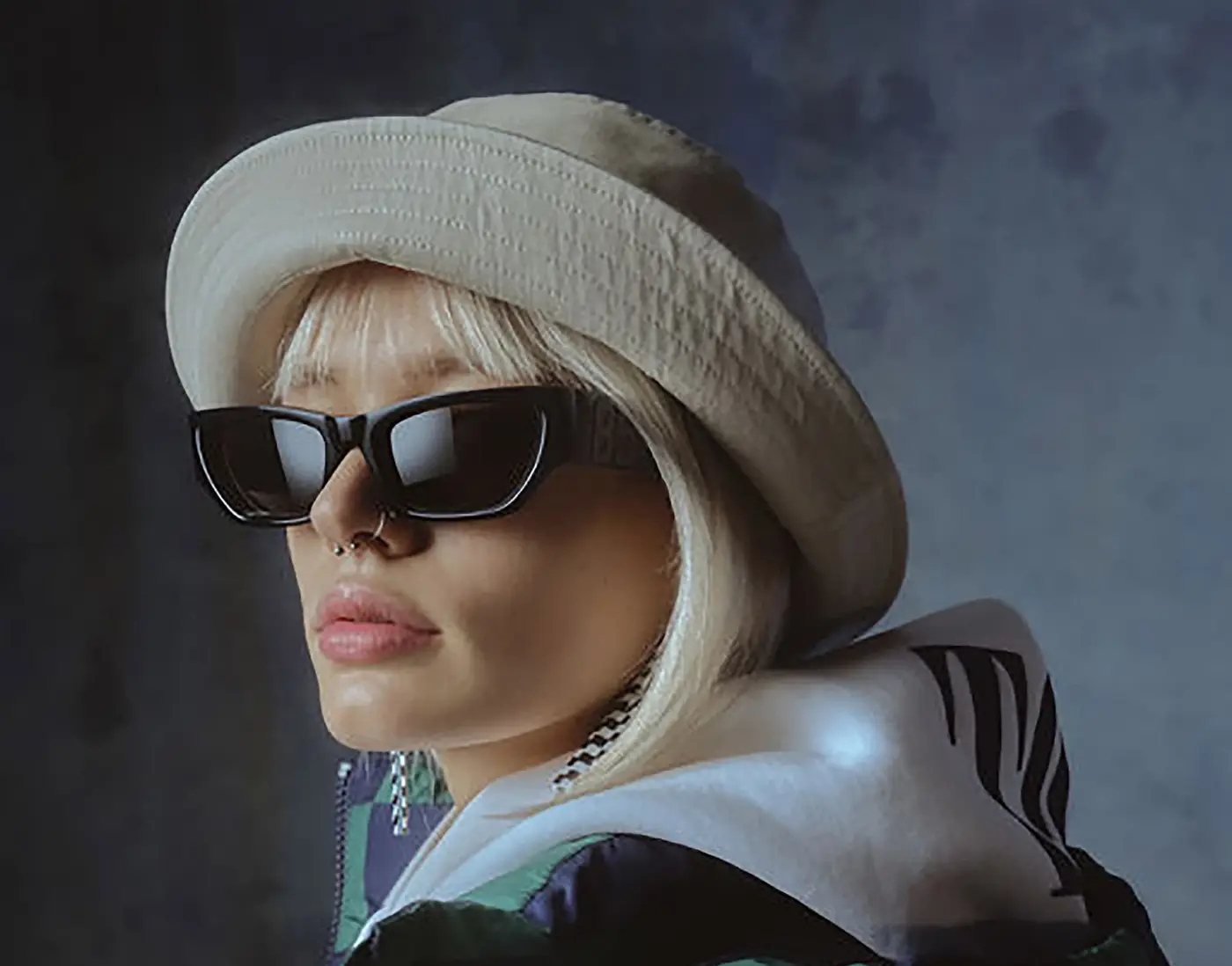 Stylish woman wearing sunglasses and a hat at Loyal Specs opticians East Ham.